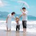 A joyful family enjoying a sunny day at Da Nang Beach, Vietnam, showcasing a heartwarming moment.